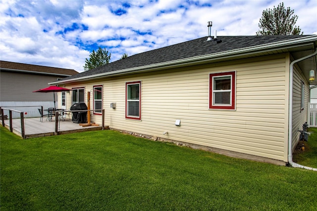 173 Empire Loop, Kalispell, MT 59901 - back of property with a lawn, a shingled roof, and a deck