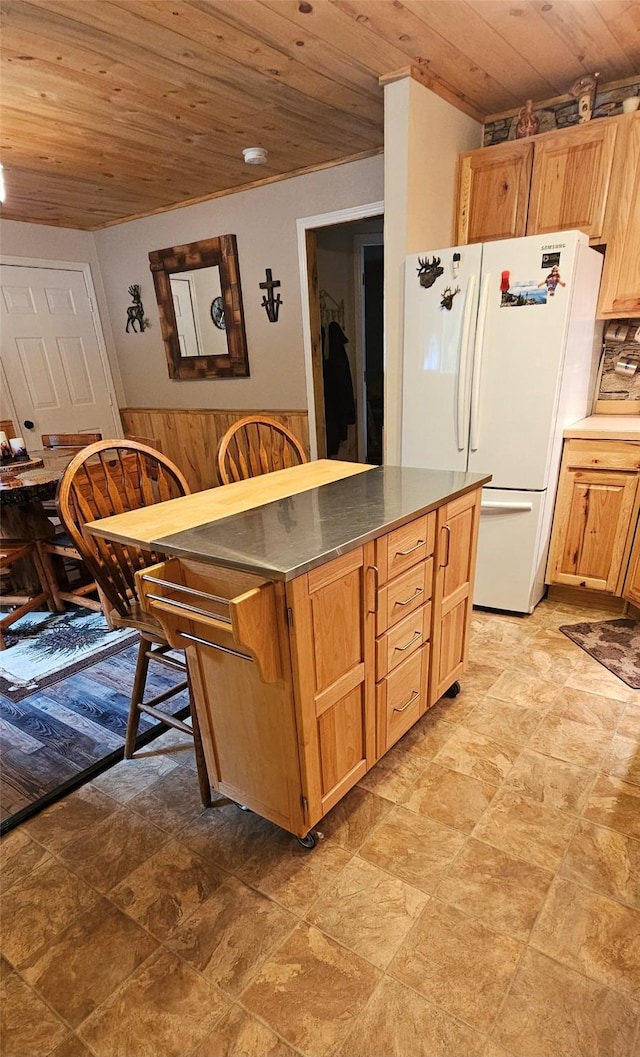 194 Whitetail Dr, Haugan, MT 59842 - kitchen featuring freestanding refrigerator, wood ceiling, a center island, stone finish floors, and dark countertops
