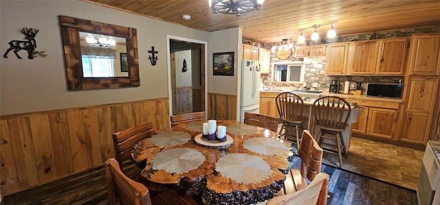 194 Whitetail Dr, Haugan, MT 59842 - dining room with wooden ceiling, wainscoting, dark wood finished floors, wood walls, and a chandelier