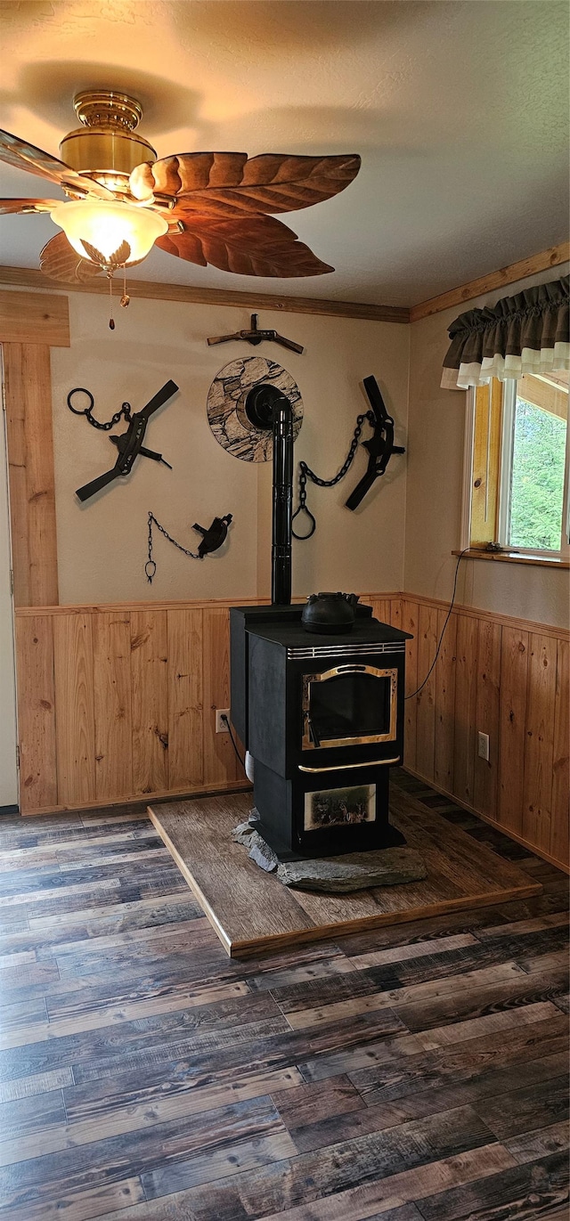 194 Whitetail Dr, Haugan, MT 59842 - detailed view of a wood stove, wood finished floors, wooden walls, a wainscoted wall, and ceiling fan