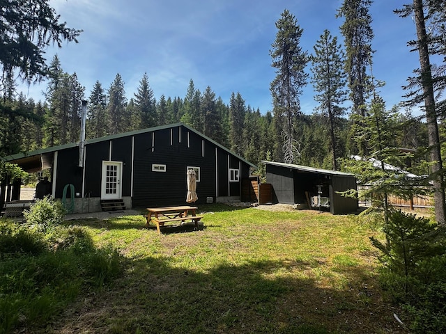 194 Whitetail Dr, Haugan, MT 59842 - rear view of house featuring entry steps, a yard, a forest view, and an outbuilding