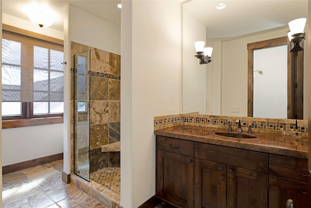 237 Harbor Dr, Bigfork, MT 59911 - bathroom featuring backsplash, tiled shower, vanity, and baseboards