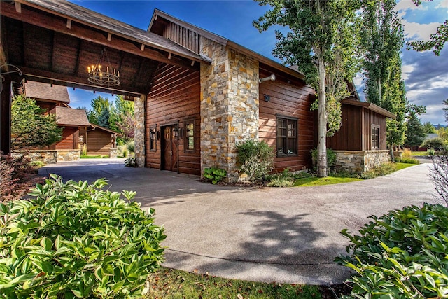 237 Harbor Dr, Bigfork, MT 59911 - view of side of property featuring stone siding, board and batten siding, and driveway