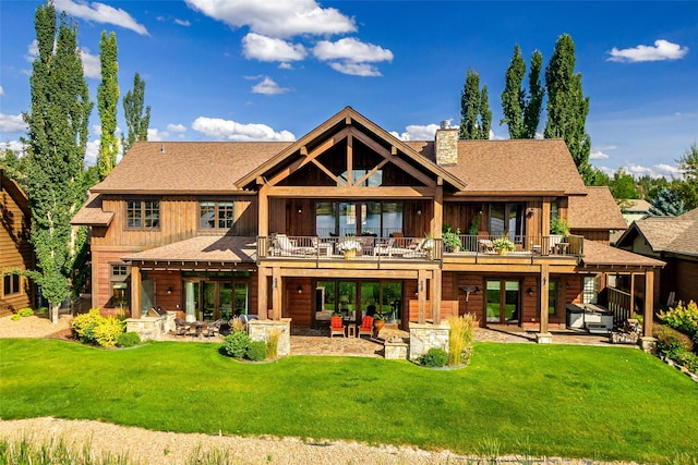 237 Harbor Dr, Bigfork, MT 59911 - rear view of house with a patio, a chimney, a lawn, and roof with shingles