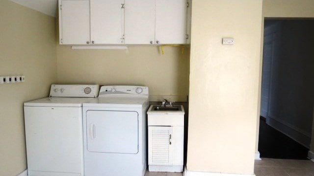 726 4th Ave S, Great Falls, MT 59405 - washroom with cabinet space, washing machine and dryer, and tile patterned flooring