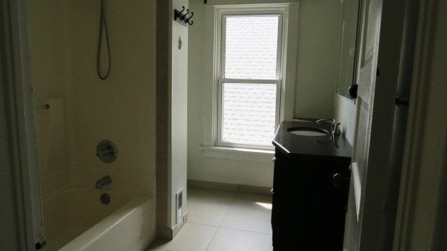 726 4th Ave S, Great Falls, MT 59405 - bathroom featuring vanity, tile patterned flooring, and washtub / shower combination