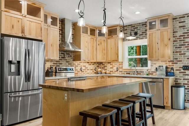 11501 Sleeman Creek Rd, Lolo, MT 59847 - kitchen with appliances with stainless steel finishes, wall chimney exhaust hood, wooden counters, light wood-style flooring, and light brown cabinetry