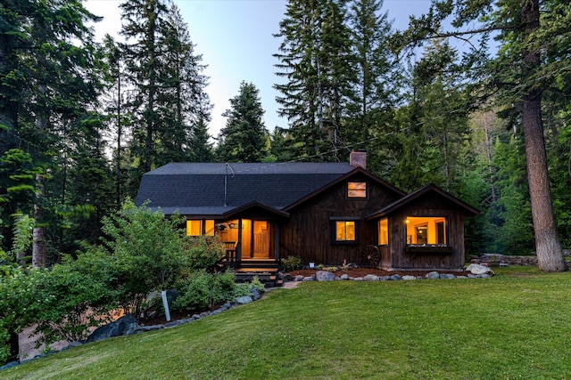 151 Handkerchief Creek Dr, Kalispell, MT 59901 - view of front of house with a chimney, a front yard, and a shingled roof