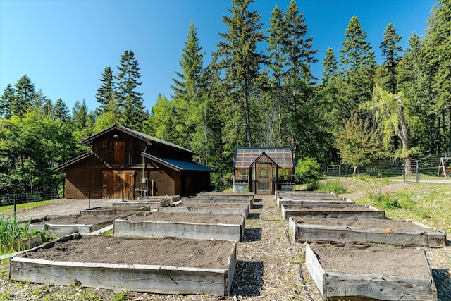 151 Handkerchief Creek Dr, Kalispell, MT 59901 - rear view of house with a vegetable garden, an outbuilding, and an exterior structure