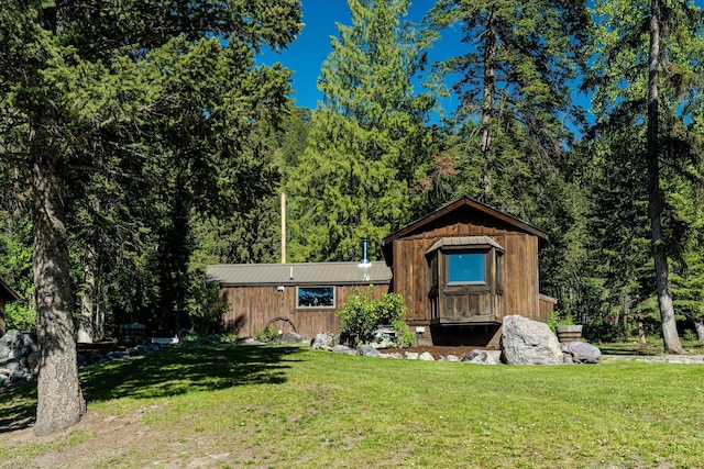 151 Handkerchief Creek Dr, Kalispell, MT 59901 - view of front of house featuring a front lawn, a view of trees, and a metal roof