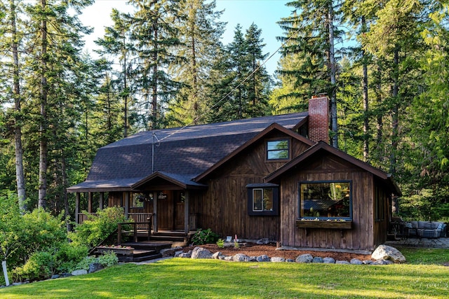 151 Handkerchief Creek Dr, Kalispell, MT 59901 - view of front of house with a front yard, a chimney, roof with shingles, and a porch