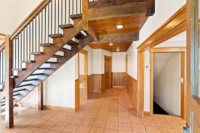 151 Handkerchief Creek Dr, Kalispell, MT 59901 - staircase featuring wainscoting, tile patterned floors, and a wood ceiling with exposed beams