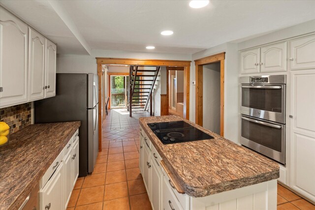 151 Handkerchief Creek Dr, Kalispell, MT 59901 - kitchen featuring appliances with stainless steel finishes, a center island, backsplash, light tile patterned floors, and recessed lighting