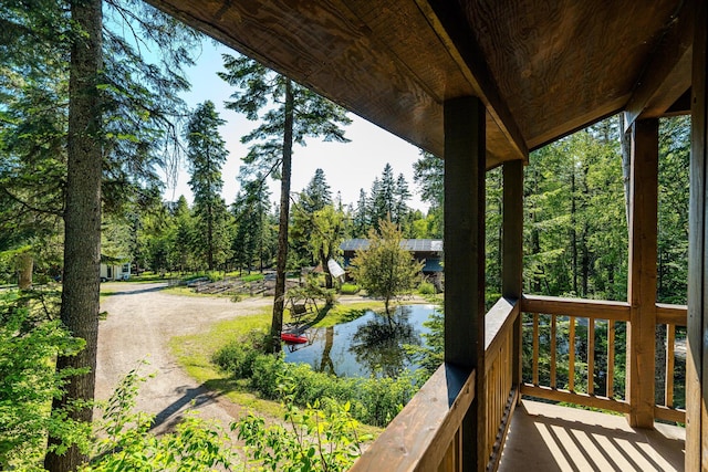 151 Handkerchief Creek Dr, Kalispell, MT 59901 - wooden terrace featuring a water view and view of wooded area
