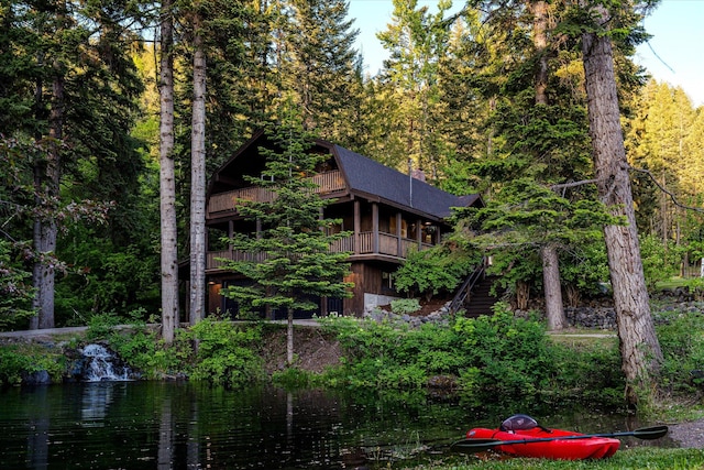 151 Handkerchief Creek Dr, Kalispell, MT 59901 - back of house with a water view, a forest view, and a shingled roof