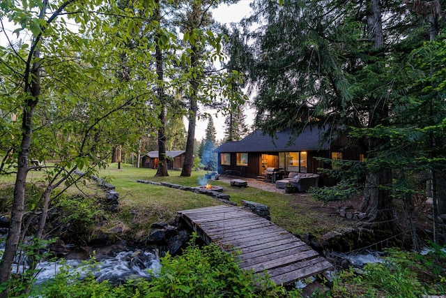 151 Handkerchief Creek Dr, Kalispell, MT 59901 - back of house with an outdoor fire pit, a lawn, and a patio