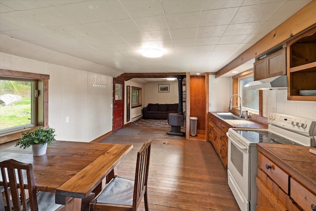 151 Handkerchief Creek Dr, Kalispell, MT 59901 - kitchen featuring white range with electric stovetop, a wood stove, dark wood finished floors, wall chimney range hood, and open shelves