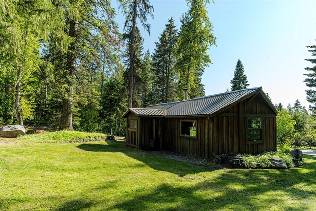 151 Handkerchief Creek Dr, Kalispell, MT 59901 - dining room featuring a wood stove, hardwood / wood-style flooring, wooden walls, and lofted ceiling