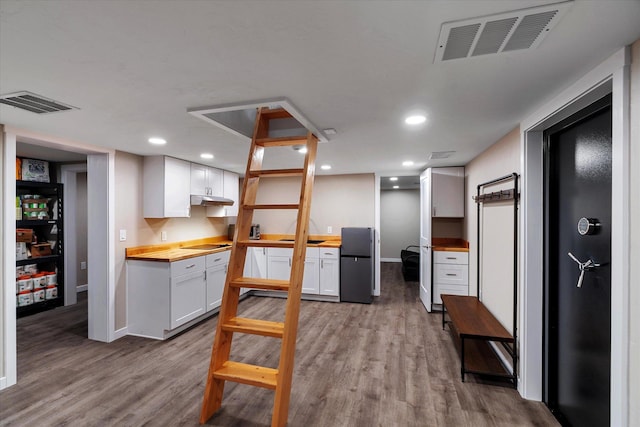 151 Handkerchief Creek Dr, Kalispell, MT 59901 - kitchen with freestanding refrigerator, butcher block counters, light wood-style flooring, white cabinetry, and under cabinet range hood