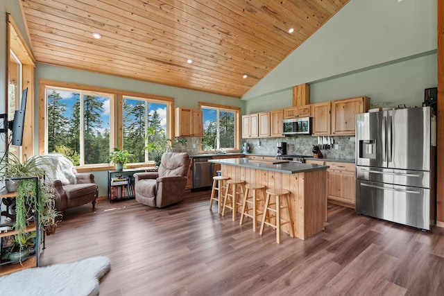 4111 Foothill Rd, Kalispell, MT 59901 - kitchen featuring stainless steel appliances, open floor plan, a center island, a breakfast bar, and decorative backsplash