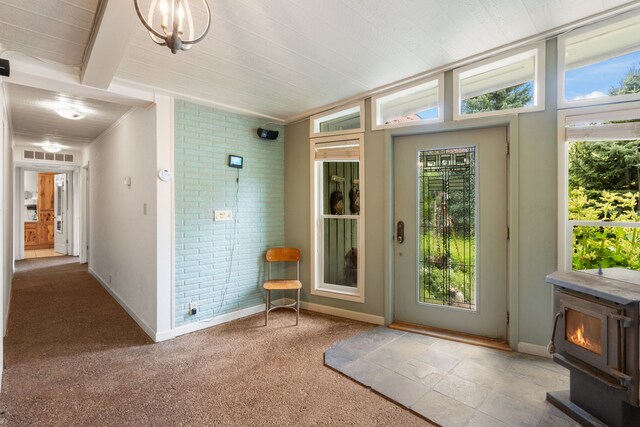 6040 Pearl Dr, Manhattan, MT 59741 - doorway to outside with a wood stove, healthy amount of natural light, brick wall, baseboards, and wooden ceiling