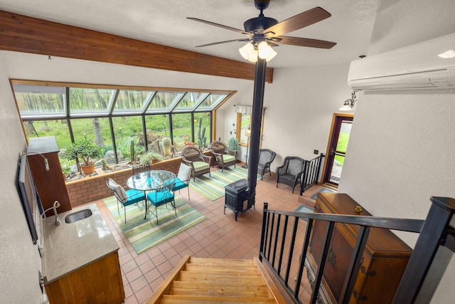 250 Sunday Ln, Kalispell, MT 59901 - living room featuring a wall unit AC, a sunroom, a ceiling fan, beamed ceiling, and tile patterned flooring