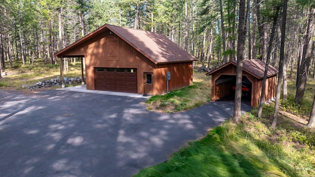 250 Sunday Ln, Kalispell, MT 59901 - garage featuring a detached garage and a view of trees