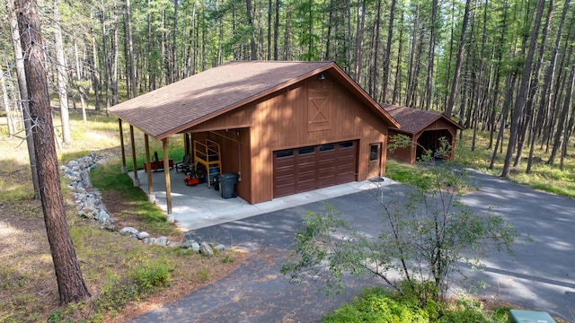 250 Sunday Ln, Kalispell, MT 59901 - detached garage with asphalt driveway and a forest view