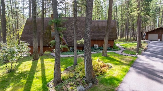 250 Sunday Ln, Kalispell, MT 59901 - view of front facade with an outdoor structure, a front lawn, a shingled roof, and a garage