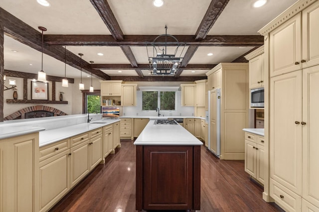 360 Plantation Dr, Kalispell, MT 59901 - kitchen with cream cabinetry, built in appliances, beamed ceiling, light countertops, and recessed lighting