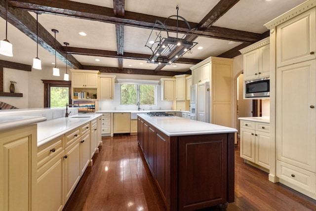 360 Plantation Dr, Kalispell, MT 59901 - kitchen featuring cream cabinetry, stainless steel microwave, dark wood-type flooring, gas stovetop, and beamed ceiling