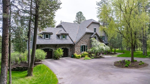 360 Plantation Dr, Kalispell, MT 59901 - french country style house featuring stone siding, curved driveway, a garage, and stucco siding
