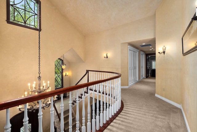 360 Plantation Dr, Kalispell, MT 59901 - hall featuring high vaulted ceiling, an upstairs landing, carpet flooring, baseboards, and a chandelier