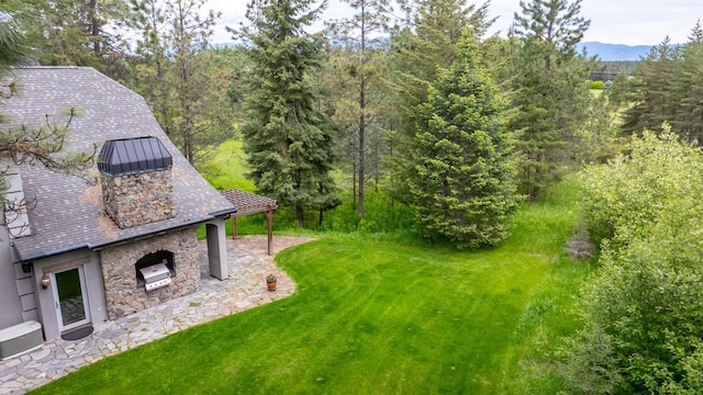 360 Plantation Dr, Kalispell, MT 59901 - view of grassy yard with a patio and a wooded view