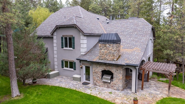 360 Plantation Dr, Kalispell, MT 59901 - back of property featuring stone siding, exterior kitchen, a patio, and a lawn