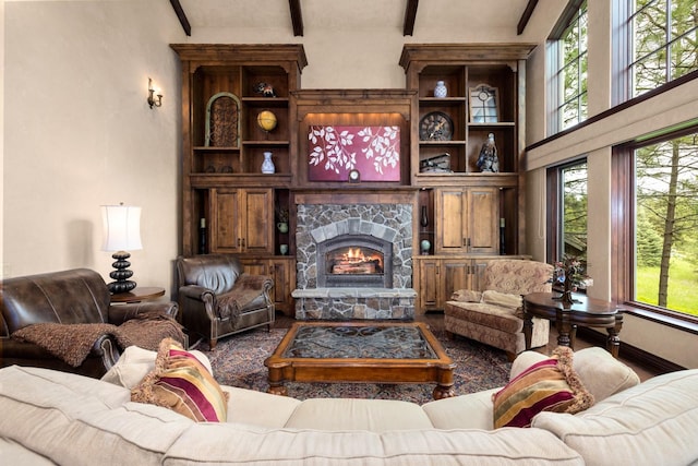 360 Plantation Dr, Kalispell, MT 59901 - living room with wood finished floors, beam ceiling, a stone fireplace, and a towering ceiling