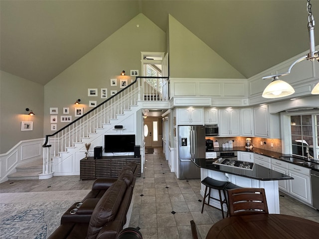 2413 Capstone Ct, Thompson Falls, MT 59873 - kitchen featuring appliances with stainless steel finishes, high vaulted ceiling, a sink, dark countertops, and open floor plan