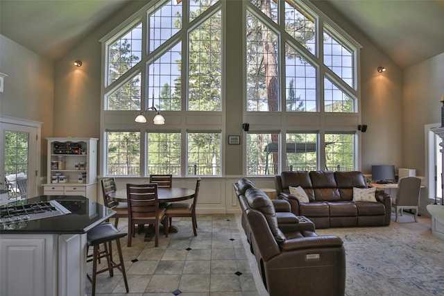 2413 Capstone Ct, Thompson Falls, MT 59873 - living room with high vaulted ceiling, light tile patterned floors, healthy amount of natural light, and a decorative wall