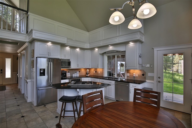 2413 Capstone Ct, Thompson Falls, MT 59873 - kitchen featuring appliances with stainless steel finishes, dark countertops, tasteful backsplash, light tile patterned floors, and lofted ceiling