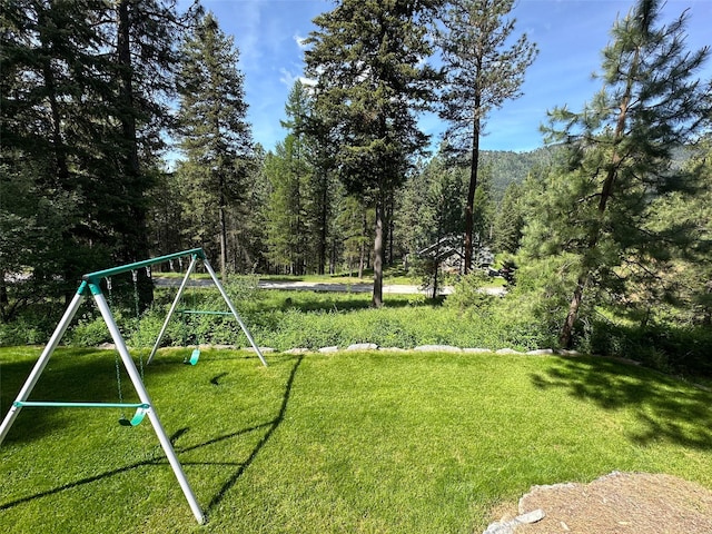 2413 Capstone Ct, Thompson Falls, MT 59873 - view of green lawn with a playground and a wooded view