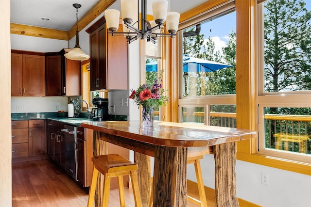 956 Falling Star Rd, Victor, MT 59875 - kitchen with a chandelier, wood finished floors, decorative light fixtures, dishwasher, and dark countertops