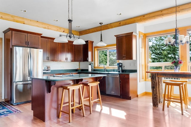 956 Falling Star Rd, Victor, MT 59875 - kitchen with stainless steel appliances, light wood finished floors, a chandelier, a kitchen island, and recessed lighting