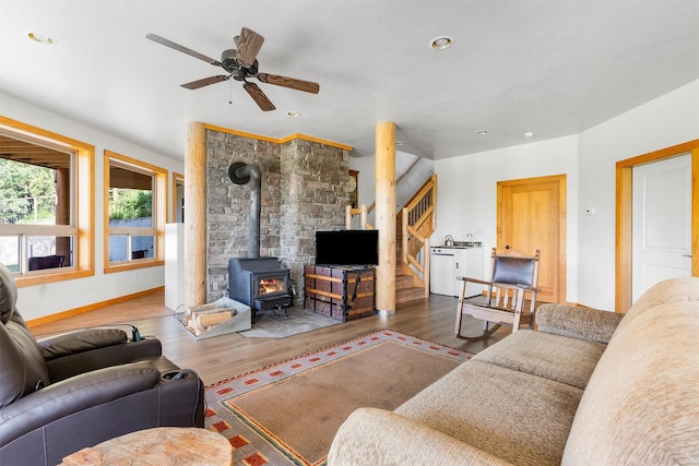 956 Falling Star Rd, Victor, MT 59875 - living room with a wood stove, wood finished floors, ceiling fan, stairs, and recessed lighting