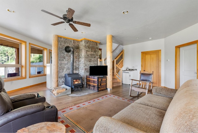 956 Falling Star Rd, Victor, MT 59875 - living area featuring a wood stove, wood finished floors, ceiling fan, recessed lighting, and stairway