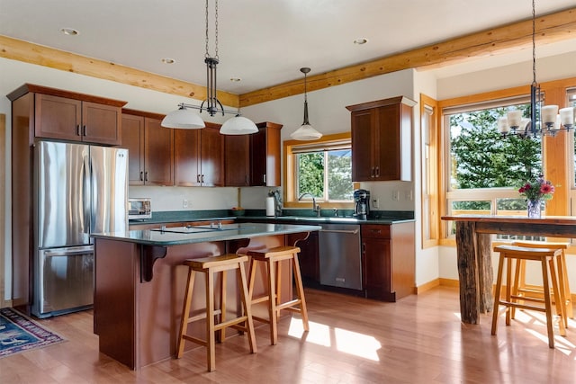 956 Falling Star Rd, Victor, MT 59875 - kitchen with stainless steel appliances, light wood-type flooring, dark countertops, recessed lighting, and beamed ceiling