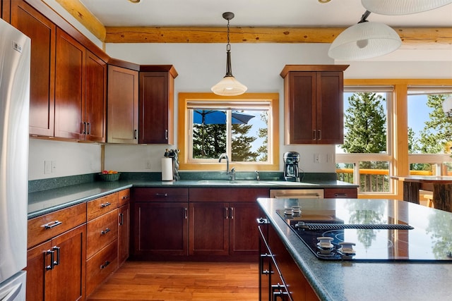 956 Falling Star Rd, Victor, MT 59875 - kitchen featuring freestanding refrigerator, black electric cooktop, plenty of natural light, dark countertops, and beamed ceiling