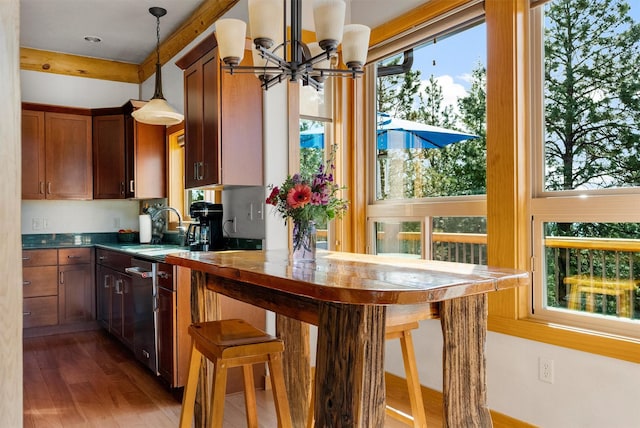 956 Falling Star Rd, Victor, MT 59875 - kitchen featuring a chandelier, wood finished floors, pendant lighting, dishwasher, and dark countertops