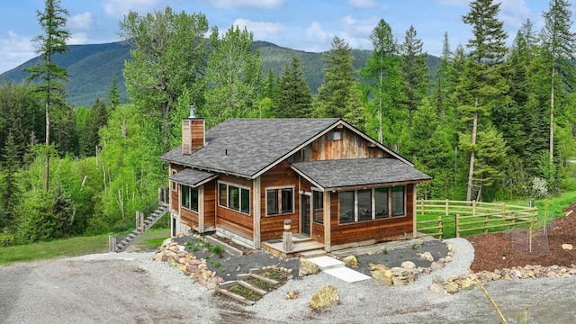 103 Glacier Hills Dr E, Martin City, MT 59926 - view of front of property featuring a forest view, a chimney, and a mountain view
