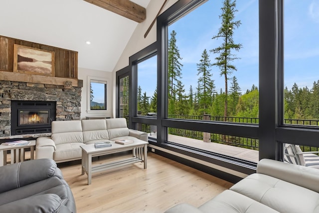 103 Glacier Hills Dr E, Martin City, MT 59926 - living room featuring light wood-style floors, beam ceiling, plenty of natural light, high vaulted ceiling, and a stone fireplace