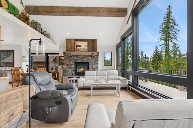 103 Glacier Hills Dr E, Martin City, MT 59926 - living room with beam ceiling, light wood-style flooring, healthy amount of natural light, a fireplace, and high vaulted ceiling